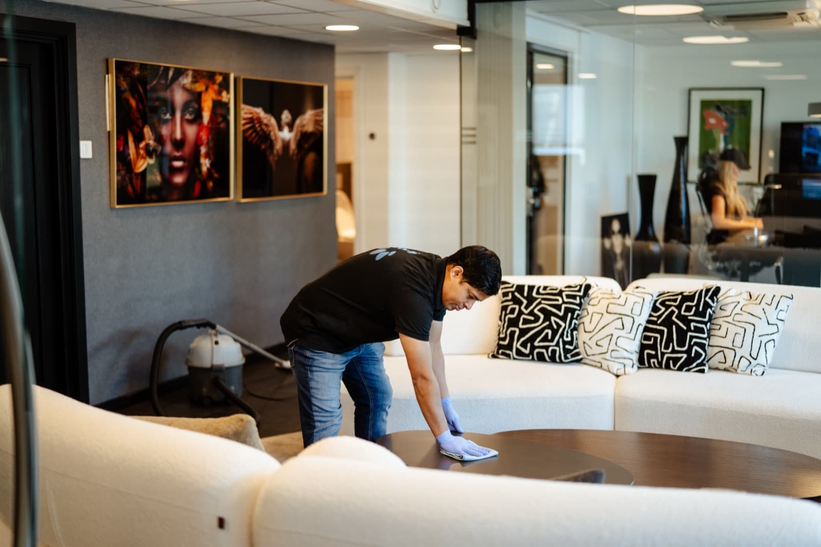Living Clean renholder tørker sofaoverflater i moderne kontorlounge